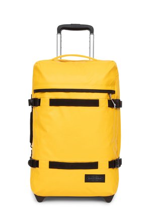 Gelbes Rollgepäck mit einem stabilen Griff, schwarzen Riemenakzenten und einer glatten, strapazierfähigen Oberfläche. Verfügt über ein Logopatch auf der Vorderseite.
