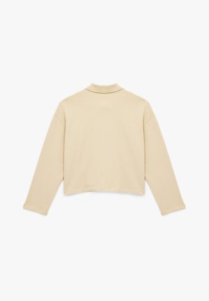 Vaaleanbeige lyhyt muotoinen collegepaita, jossa on pitkät hihat ja laskettavat kaulukset. Sileä pinta ja minimalistinen muotoilu, esitetty takaa.