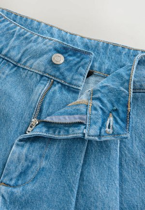Lichtblauwe spijkerbroeken van denim met een rits, koperen knoopsluiting en contrasterende stiksels. De tailleband heeft een subtiele rafelrand.