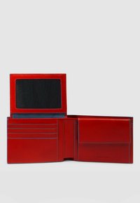 Portafoglio in pelle rossa, dotato di uno scomparto trasparente per documenti d'identità, numerosi slot per carte, interno texturizzato e una tasca laterale con chiusura a patta.
