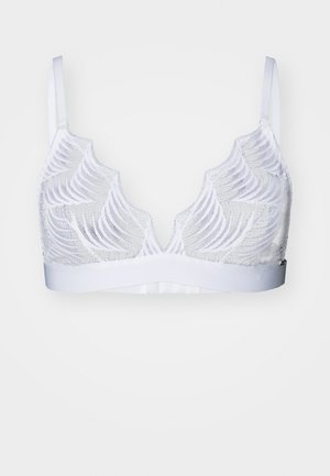 White bralette with sheer lace overlay featuring wavy patterns, adjustable straps, and a smooth underband. Lightweight and soft texture.