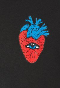 Röd hjärta med blå artärer och en central blå ögondesign på en svart tygbakgrund. Illustrationen har djärva konturer och detaljer.