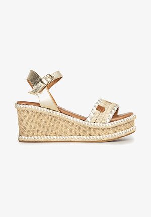 Sandale compensée avec plateforme en paille tissée, bride de cheville dorée avec boucle et bride avant ouverte avec surpiqûres décoratives.