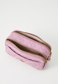 Roze gegraveerde leren cosmetica tas met twee gouden ritsen en interne opbergruimtes. Kenmerkt een gestructureerd oppervlak en gouden hardware accenten.