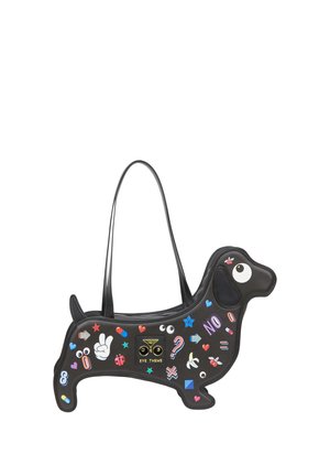 Black handbag shaped like a dachshund dog decorated with colorful patches including eyes, hearts, pills, and peace signs.