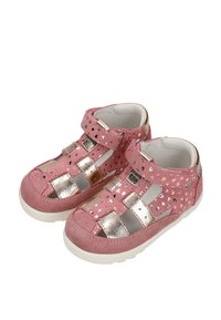 Sandales roses pour tout-petit avec motifs de cœurs métalliques, brides dorées, fermetures à velcro et semelles blanches rembourrées.