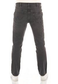 Jeans de mezclilla gris oscuro con un diseño de corte recto, que incluyen dos bolsillos traseros con un patrón de costura en zigzag y una etiqueta de marca de cuero.