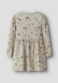 Robe pour tout-petit à manches longues beige avec taille froncée et imprimé floral et champignon en petits motifs dans des tons doux.