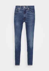 Jeans de mezclilla azul oscuro con corte ajustado, que cuentan con cierre de botones, diseño de cinco bolsillos y un ligero desvanecimiento en la parte delantera para dar textura.