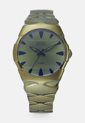 Montre en métal doré avec un cadran rond en verre teinté bleu. Présente de grands index horaires et un bracelet texturé à maillons. Résistante à l'eau jusqu'à 5 bars.