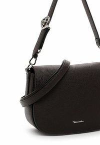 Sac en cuir marron foncé à bandoulière avec une surface texturée, une forme courbée, une sangle ajustable et des détails en métal argenté.