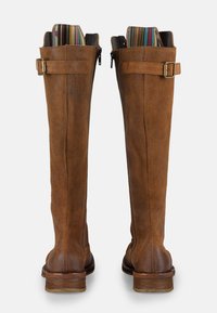 Stivali alti in suede marrone con tacco impilato, chiusura con zip e un colore interno a strisce vivaci. Dotati di una cintura regolabile con fibbia.