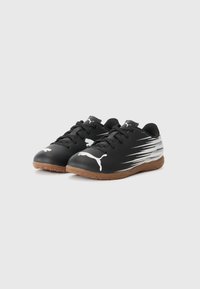 Zapatillas deportivas negras con parte superior sintética texturizada, acentos y logotipo blancos, suela de goma con acabado en tono marrón, presentan un diseño con cordones.