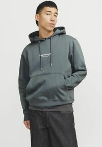 Dark green hoodie with a front pocket, adjustable drawstring hood, and a white logo on the chest. Smooth fabric with a relaxed fit.