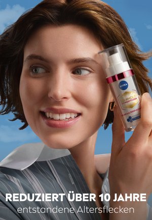 Nivea Luminous Serum in a clear bottle with a pump dispenser, featuring a silver and pink accent, against a blue background.