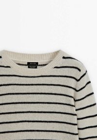 Pull en maille couleur crème avec des rayures horizontales noires et un col rond, en 100 % cachemire, vu de face.