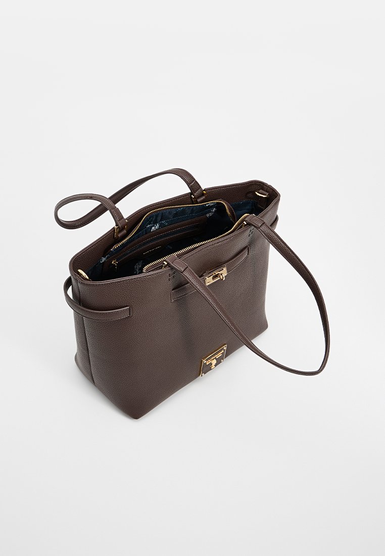 Bolso de cuero marrón con un diseño estructurado, dos asas, detalles en dorado y una apertura con cremallera. El interior cuenta con un forro floral.