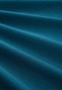 Teal színű, textúrált anyag, átlós hajtásokkal; finom rácsos mintázattal, puha felülettel és enyhe fényű bevonattal rendelkezik. Ülésbevitelhez vagy ruházathoz is alkalmas.