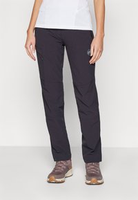 Black outdoor pants made from lightweight, durable fabric. Features a zippered pocket and a logo accent. Paired with gray hiking shoes.