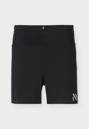 Shorts de sport noirs taille haute avec tissu texturé et logo réfléchissant près de l'ourlet inférieur droit, sur un fond clair.