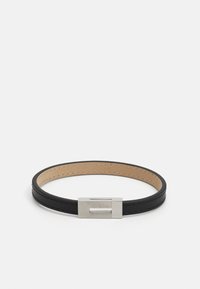 Black leather bracelet with a smooth texture, featuring a silver metal clasp. The interior is tan, highlighted by stitched detailing.