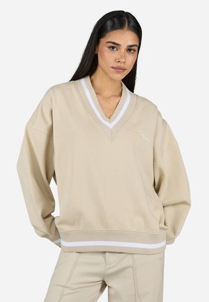 Sweatshirt oversized bege com decote em V, colarinho riscado branco e detalhe branco na bainha, feito de um suave material de toalha.