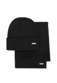 Czarny dziany zestaw czapki i dopasowanego szalika. Oba elementy mają prążkowaną teksturę oraz małą metkę z marką na szaliku.