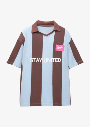 Brun og lyseblå stribet kortærmet polo skjorte med v-hals; har et pink mærke med "STAY UNITED" trykt i hvid.