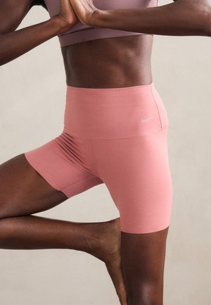 Pantaloni scurți atletici roz, cu talie înaltă, dintr-un material elastic și neted, cu un logo pe lateral. Caracterizează un design ajustat, cu un detaliu strâns în jurul taliei.