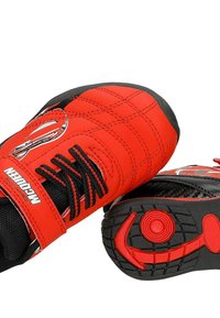 Basket rouge pour enfants avec lacets noirs, semelles noires et un motif de voiture de dessin animé, montrant les vues de dessus et de dessous.