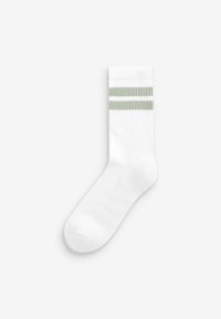 Chaussettes blanches côtelées avec deux rayures horizontales vertes près du haut. Texture douce avec un design classique de longueur crew.