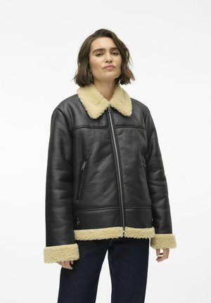 Zwarte leren jas met een crèmekleurige nep-shearling kraag en manchet, met een rits aan de voorkant en zijzakken. Verdeeld met een gladde textuur en een gestructureerde pasvorm.