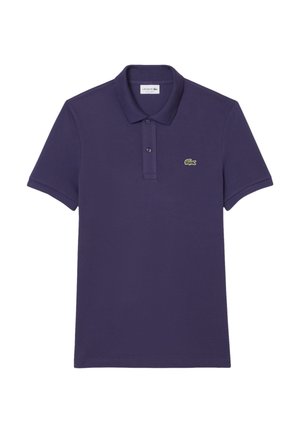 Violetti polo-paita, joka on valmistettu puuvillasta. Paitassa on kolmen painonapin kaulus ja pieni vihreä Lacoste-logo vasemmassa rinnassa. Lyhyet hihat.