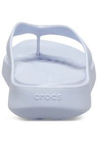 Chanclas Crocs blancas con plantilla contorneada y tira texturizada mostradas desde la parte trasera.