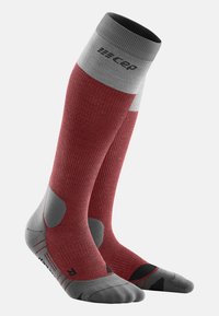 Calze compressive con un corpo rosso e dettagli grigi, texture a coste, zone imbottite e dettagli neri sulle dita e sui lati.