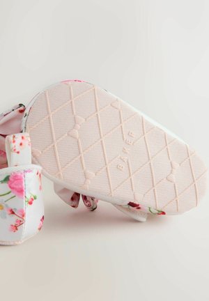 Virágmintás gyerekcipő világos rózsaszín, texturált gumitalppal, párnázott bokapánttal és puha szövet felsőrésszel.