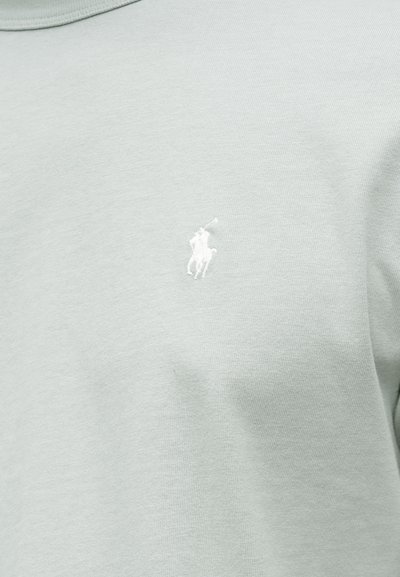 Svetlozelené bavlnené tričko s malým bielym vyšívaným logom koňa na ľavej strane hrude. Jemná textúra a klasický strih s okrúhlym výstrihom.