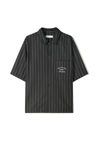 Košile s krátkým rukávem z černé látky s bílými vertikálními pruhy. Obsahuje náprsní kapsu s vyšívaným textem na levém prsu.