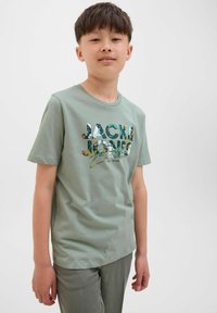 Zelena pamučna majica s multikolor dizajnom "JACK & JONES". Kratki rukavi, okrugli izrez, ležeran kroj.