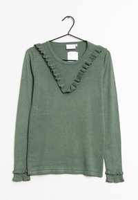 Pull vert à manches longues avec bordure à volants en forme de V sur la poitrine et poignets à volants, suspendu sur un cintre noir contre un fond blanc.