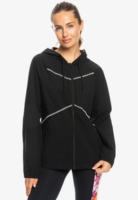 Black hooded jacket made of lightweight material. Features reflective accents, a front zipper, and two side pockets.