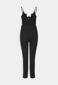Body nero con dettagli in pizzo e spalline regolabili, abbinato a pantaloni neri eleganti con silhouette aderente e cintura.