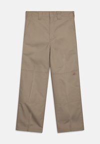 Pantalons larges beiges en tissu solide, dotés de deux poches avant et d'un petit logo sur le côté. Détails cousus le long des jambes.