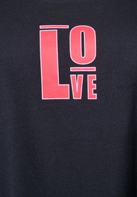 Juodas medvilnės marškinėliai su dideliu raudonu tekstu, kuris sako "LOve", turintys ryškų, grafišką dizainą ir kontrastingus spalvų elementus.