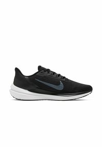 Zapatilla deportiva negra con una parte superior texturizada, que presenta un logo de swoosh en gris oscuro, una entresuela blanca ligera y una suela de goma.