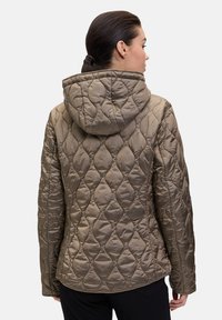 Veste matelassée de couleur vert olive avec capuche. Elle présente un motif texturé d'ovales et des coutures discrètes. Conception légère et ajustée.