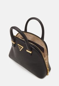 Sac à main noir texturé avec deux poignées, fermeture éclair et détails dorés, partiellement ouvert pour montrer la doublure intérieure beige avec motif du logo Guess.