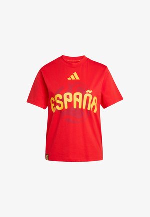 Rød T-shirt med korte ærmer med gul "ESPAÑA"-tekst og Adidas-logo ovenover, med et subtilt basketballmotiv i baggrunden.