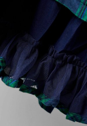 Granatowa sukienka z falbanką w stylu tiered, wykonana z przezroczystego tiulu, z akcentem w zieloną kratkę. Zawiera gładką fakturę tkaniny oraz warstwowy design.