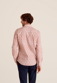 Gestreept shirt in koraal met een witte golfachtige print, voorzien van een button-down kraag en omgeslagen mouwen, gemaakt van lichtgewicht stof.